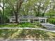 Charming single-story home with lush landscaping, mature trees, and a welcoming entryway at 610 Kittredge Dr, Orlando, FL 32805