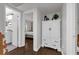 Hallway with white armoire and doorway views of bath and bedroom with dark wood floors and white walls at 610 Kittredge Dr, Orlando, FL 32805