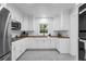 Bright kitchen with white cabinets, a gray tile floor, butcher block counters and stainless steel appliances at 610 Kittredge Dr, Orlando, FL 32805