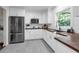 Modern kitchen featuring white cabinets, stainless steel appliances, butcher block countertops, and tile flooring at 610 Kittredge Dr, Orlando, FL 32805