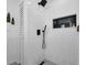 Modern walk-in shower with black fixtures, white tile, a built-in niche, and graphic patterned floor at 610 Kittredge Dr, Orlando, FL 32805