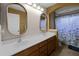 Bathroom with double sinks, a large counter, and a shower/tub combination with a seashell-themed curtain at 7621 Brightwater Pl, Oviedo, FL 32765