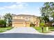 Two-story home with three car garage, manicured lawn, and mature trees at 7621 Brightwater Pl, Oviedo, FL 32765
