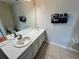 Bright bathroom featuring a vanity with a sink, a large mirror, and neutral-toned tile flooring at 7682 Sir Kaufmann Ct, Kissimmee, FL 34747