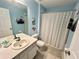 Bright bathroom with blue walls featuring a shower with curtain and a vanity sink at 7682 Sir Kaufmann Ct, Kissimmee, FL 34747