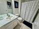 Clean bathroom with a vanity, toilet, and shower with striped shower curtain at 7682 Sir Kaufmann Ct, Kissimmee, FL 34747