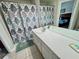 Well-lit bathroom with double-sink vanity, decorative shower curtain, and tiled flooring for a clean, modern look at 7682 Sir Kaufmann Ct, Kissimmee, FL 34747