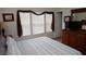 Comfortable bedroom with a dresser, TV, and natural light from the three windows at 7682 Sir Kaufmann Ct, Kissimmee, FL 34747