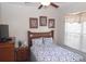 Bright bedroom with a wood frame bed, blue and white comforter, and a large window at 7682 Sir Kaufmann Ct, Kissimmee, FL 34747