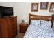 Cozy bedroom with a wood frame bed, blue and white comforter, and a matching dresser and nightstand at 7682 Sir Kaufmann Ct, Kissimmee, FL 34747