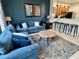Cozy living room with comfortable blue seating, modern decor, and an open layout to the kitchen at 7682 Sir Kaufmann Ct, Kissimmee, FL 34747