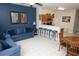 Open-concept living space with tile floors, breakfast bar seating, and contemporary blue sofa at 7682 Sir Kaufmann Ct, Kissimmee, FL 34747
