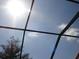 Screened patio ceiling view with a bright sunny blue sky with clouds in the background at 7682 Sir Kaufmann Ct, Kissimmee, FL 34747