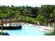 Resort-style community pool surrounded by palm trees, sun loungers, and lush landscaping at 7682 Sir Kaufmann Ct, Kissimmee, FL 34747