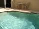 Private patio pool area, perfect for outdoor relaxation, with a table and chairs at 7682 Sir Kaufmann Ct, Kissimmee, FL 34747