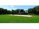 Outdoor sand volleyball court surrounded by lush trees at 7682 Sir Kaufmann Ct, Kissimmee, FL 34747