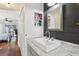 Bathroom with a modern sink and dark wood accent wall with shelving and decor at 857 Marquis Ct, Kissimmee, FL 34759