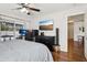 A main bedroom with hardwood floors, large bed, computer and view of the lanai at 857 Marquis Ct, Kissimmee, FL 34759