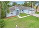Beautiful blue exterior with well-maintained lawn, archway entry, and palms at 857 Marquis Ct, Kissimmee, FL 34759