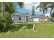 A charming blue single-story home featuring an arched entryway and two-car garage, complemented by a lush green lawn at 857 Marquis Ct, Kissimmee, FL 34759