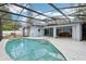 Enclosed pool area with blue painted home, tile pool, and screen at 857 Marquis Ct, Kissimmee, FL 34759