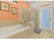 Bright bathroom featuring a soaking tub, glass-enclosed shower, and decor at 8912 Rhodes St, Kissimmee, FL 34747