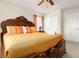 Luxurious bedroom featuring a dark wood bed frame with quilted gold bedspread, and soft natural lighting at 8912 Rhodes St, Kissimmee, FL 34747