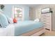 Bright bedroom featuring a large window, queen bed with turquoise bedding, and a dresser with a TV at 8912 Rhodes St, Kissimmee, FL 34747
