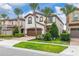 Stunning two-story home featuring a brown garage door, tile roofing, landscaped yard, and elegant palm trees at 8912 Rhodes St, Kissimmee, FL 34747