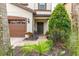 Inviting front entrance with a brown door, lush landscaping, and a brick walkway, creating a warm welcome at 8912 Rhodes St, Kissimmee, FL 34747