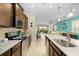 Open kitchen with granite countertops, stainless steel appliances, and views into the living room at 8912 Rhodes St, Kissimmee, FL 34747