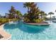 Scenic lazy river with clear blue water, lush landscaping, and tropical palm trees at 8912 Rhodes St, Kissimmee, FL 34747