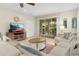 Cozy living room with sliding glass doors to the pool area, a white couch, and a wooden TV stand at 8912 Rhodes St, Kissimmee, FL 34747