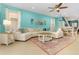 Bright living room with a white sectional couch, colorful rug, and coastal-themed decor at 8912 Rhodes St, Kissimmee, FL 34747