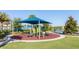 Community playground with sunshade on a manicured lawn with mature landscaping with a pond in the background at 8912 Rhodes St, Kissimmee, FL 34747