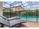 Private screened pool area with chaise lounge chairs and lush landscaping at 8912 Rhodes St, Kissimmee, FL 34747