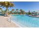 Resort style pool featuring sun loungers and cabanas with bright umbrellas and palm trees at 8912 Rhodes St, Kissimmee, FL 34747