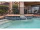 Featuring a small water fall feature, the screen enclosed pool is equipped with a safety fence at 8912 Rhodes St, Kissimmee, FL 34747