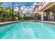 Screened in pool featuring tile trim, a small water fall feature, and safety fence at 8912 Rhodes St, Kissimmee, FL 34747