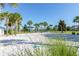 Community sand volleyball court surrounded by palm trees and manicured landscaping in a resort-style community at 8912 Rhodes St, Kissimmee, FL 34747