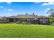 A well-manicured backyard featuring an expansive green lawn, a cozy patio, and charming garden beds at 9324 Carolview Way, Orlando, FL 32836