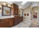 Elegant bathroom featuring granite counters, cherry cabinetry, and a skylight at 9324 Carolview Way, Orlando, FL 32836