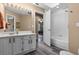Bright bathroom featuring white cabinets, large mirror, walk-in shower and vinyl flooring at 9324 Carolview Way, Orlando, FL 32836