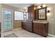Elegant bathroom featuring granite counters, cherry cabinetry, and abundant natural light at 9324 Carolview Way, Orlando, FL 32836