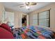 Bedroom with window, ceiling fan, carpet, closet and bed with quilt and side table at 9324 Carolview Way, Orlando, FL 32836