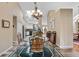 Open dining room with a glass table and an elegant chandelier, flowing into the kitchen at 9324 Carolview Way, Orlando, FL 32836