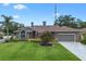 Beautiful exterior of a single-Gathering home with lush landscaping, a well-kept lawn, and a driveway at 9324 Carolview Way, Orlando, FL 32836