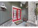 Detailed shot of the red double front doors with a cozy sitting chair and decorative elements at 9324 Carolview Way, Orlando, FL 32836