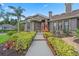 Inviting front entrance with a red door, brick accents, and lush landscaping along the walkway at 9324 Carolview Way, Orlando, FL 32836