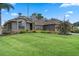 Well-maintained front yard with green lawn, palm tree, and colorful landscaping enhancing the home's curb appeal at 9324 Carolview Way, Orlando, FL 32836